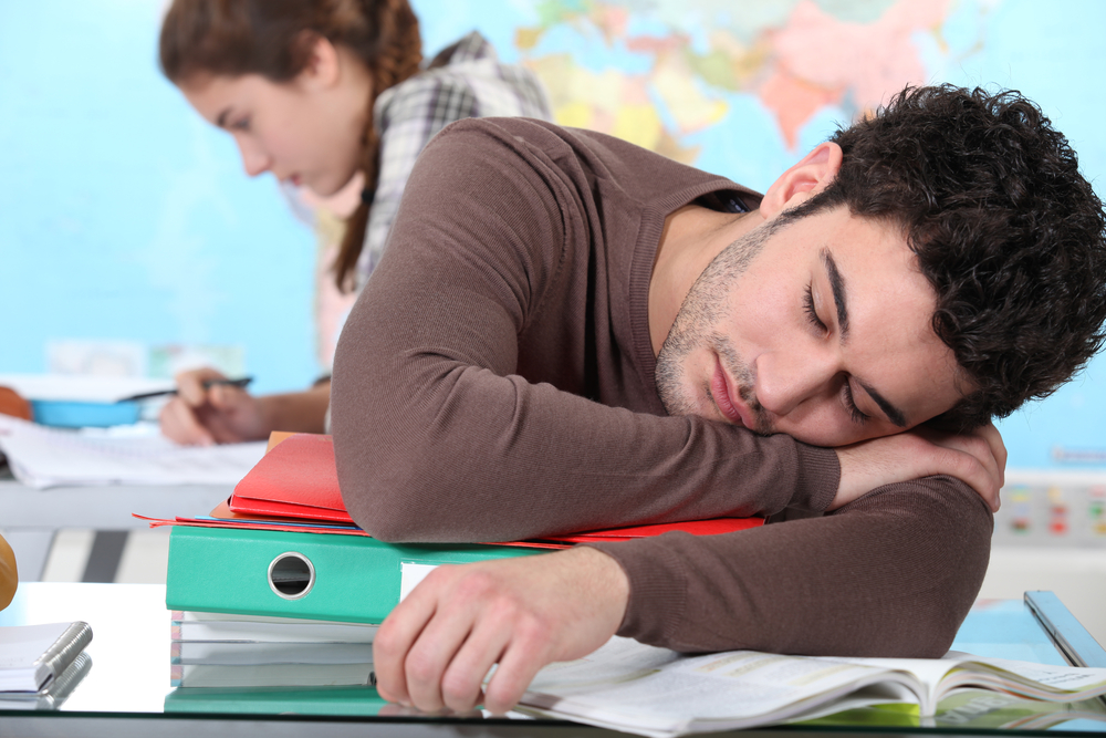 Young man with narcolepsy sleeping during a lecture